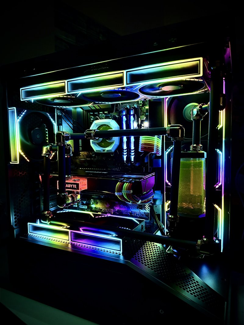 Black gaming PC with rigid liquid-cooling tubes, a coolant reservoir and multicolour RGB fans