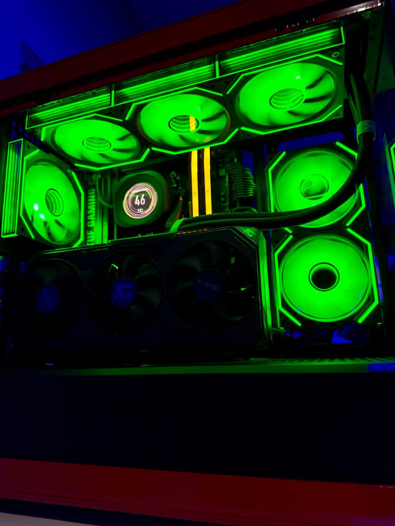 Black gaming PC illuminated by green RGB fans