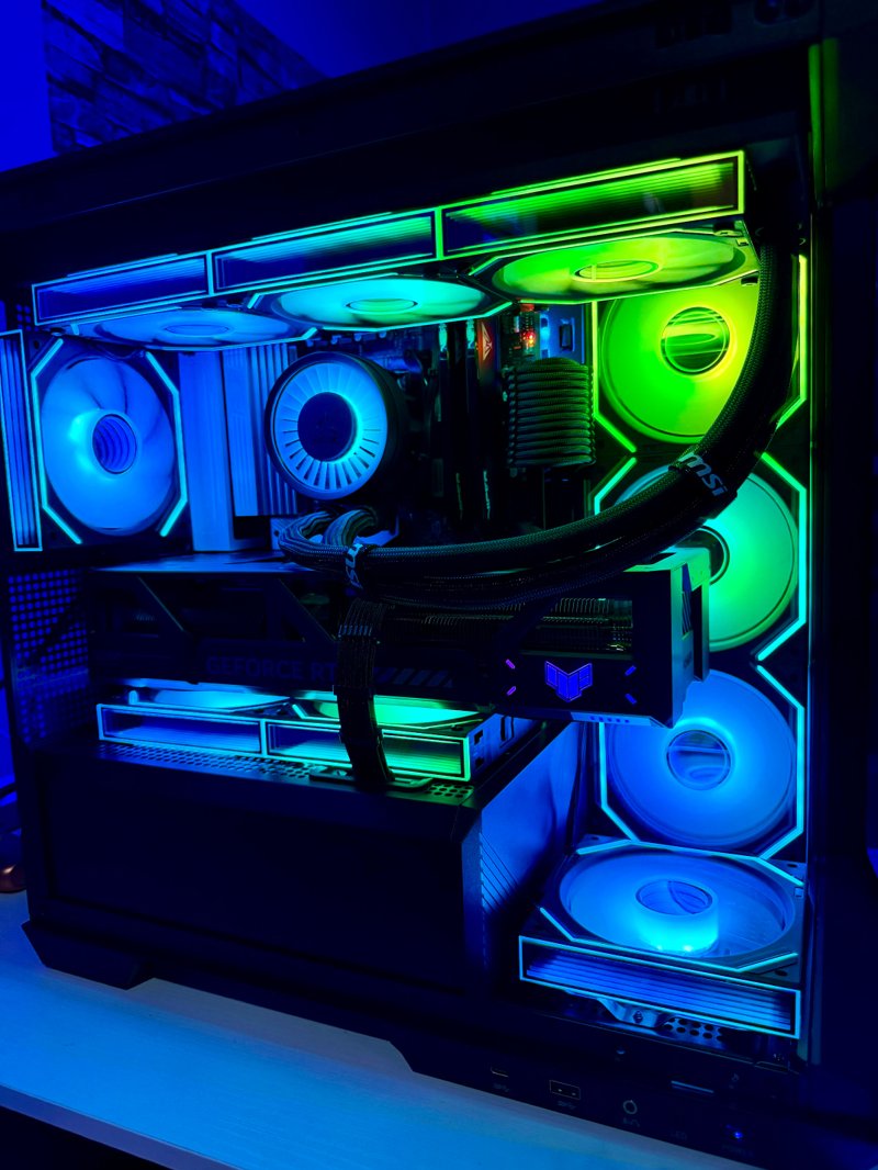 Black gaming PC with blue and green RGB lighting and a liquid cooler