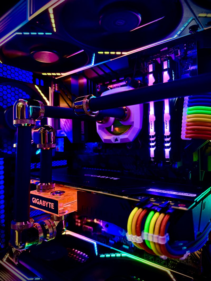 Close-up of a black gaming PC with RGB memory and illuminated power cables