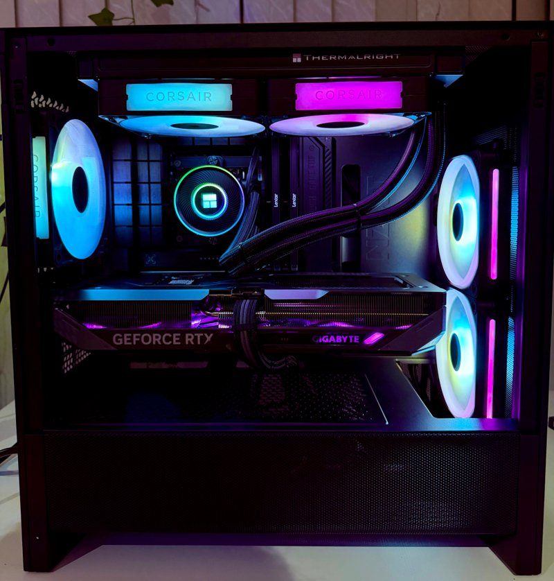 Black gaming PC with cyan and magenta lighting and a liquid cooler